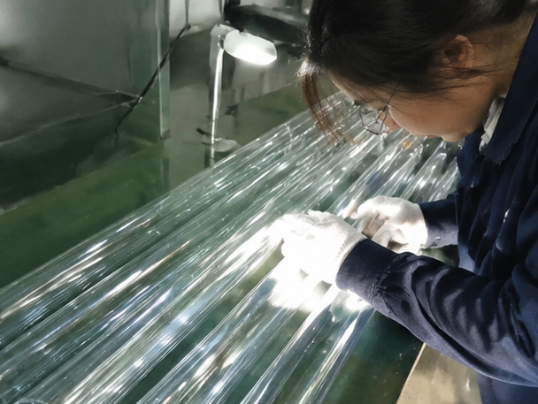 Engineer inspecting quartz glass tube dimensions during quality control process